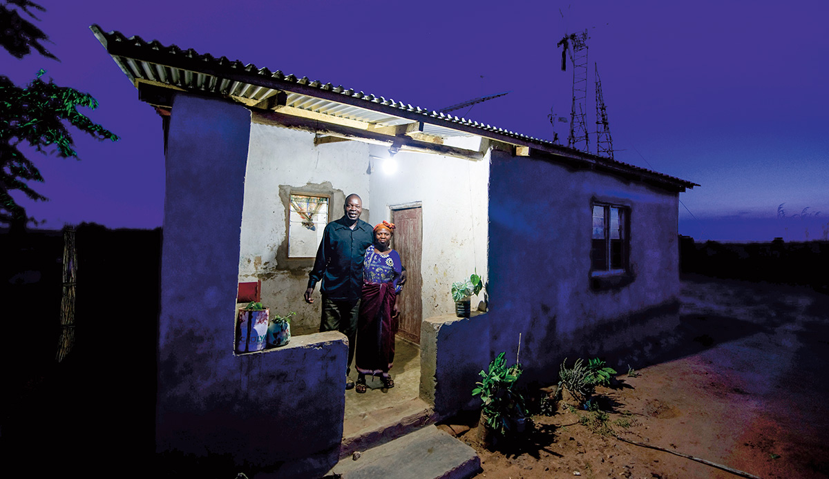 Image of two people posing outside of their home in Africa