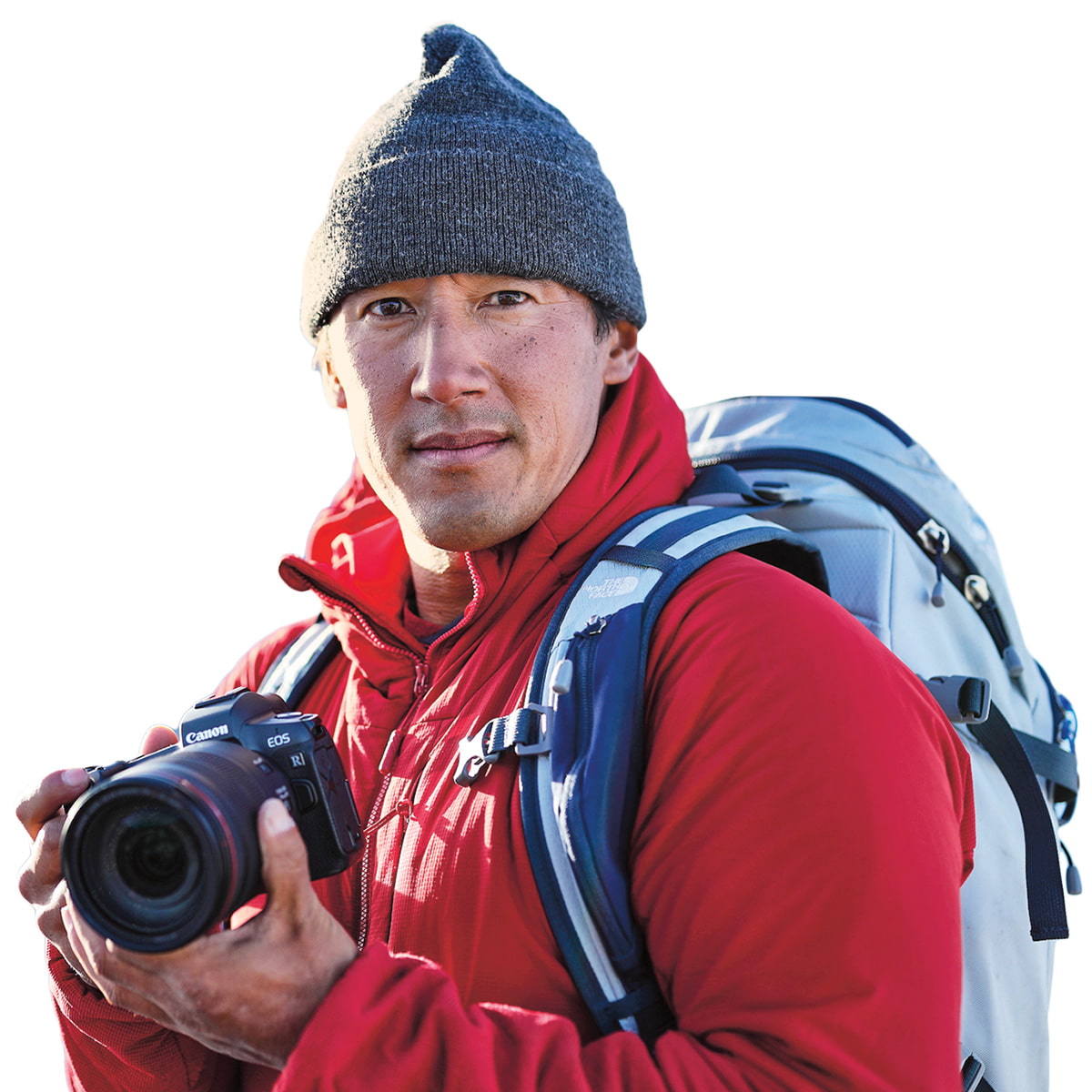 Photo of a person with large backpack, winter clothing, and a camera in hand