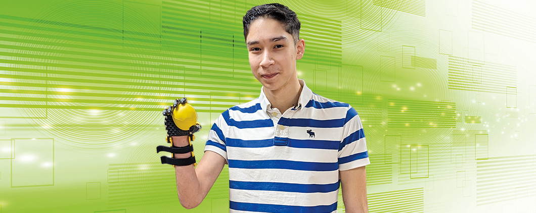 Image of a teen with a 3D printed hand, holding a ball