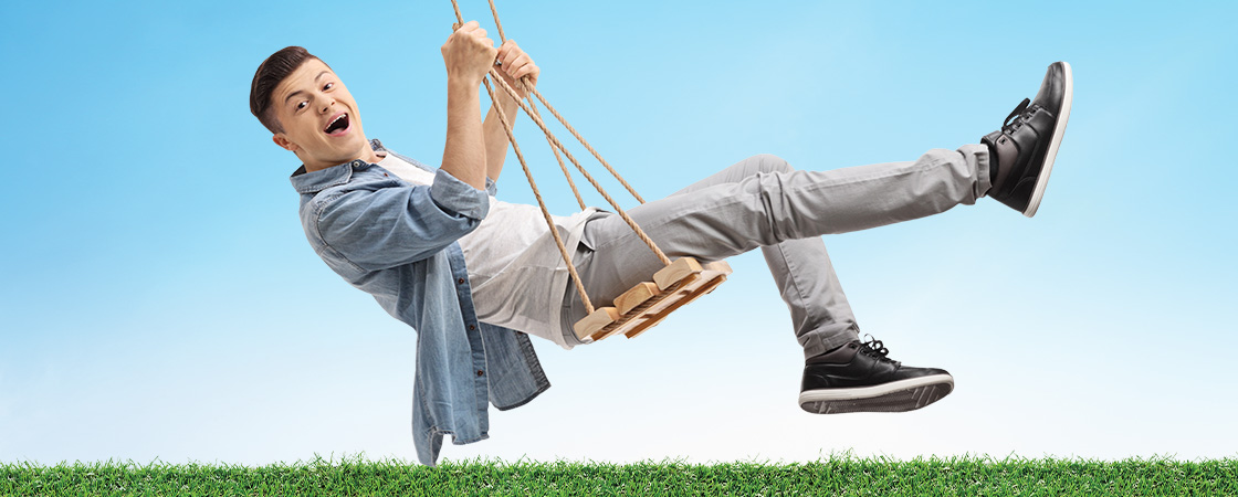 Image of a person smiling on a wooden swing