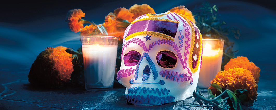 Image of a beautifully decorated skull surrounded by candles and flowers